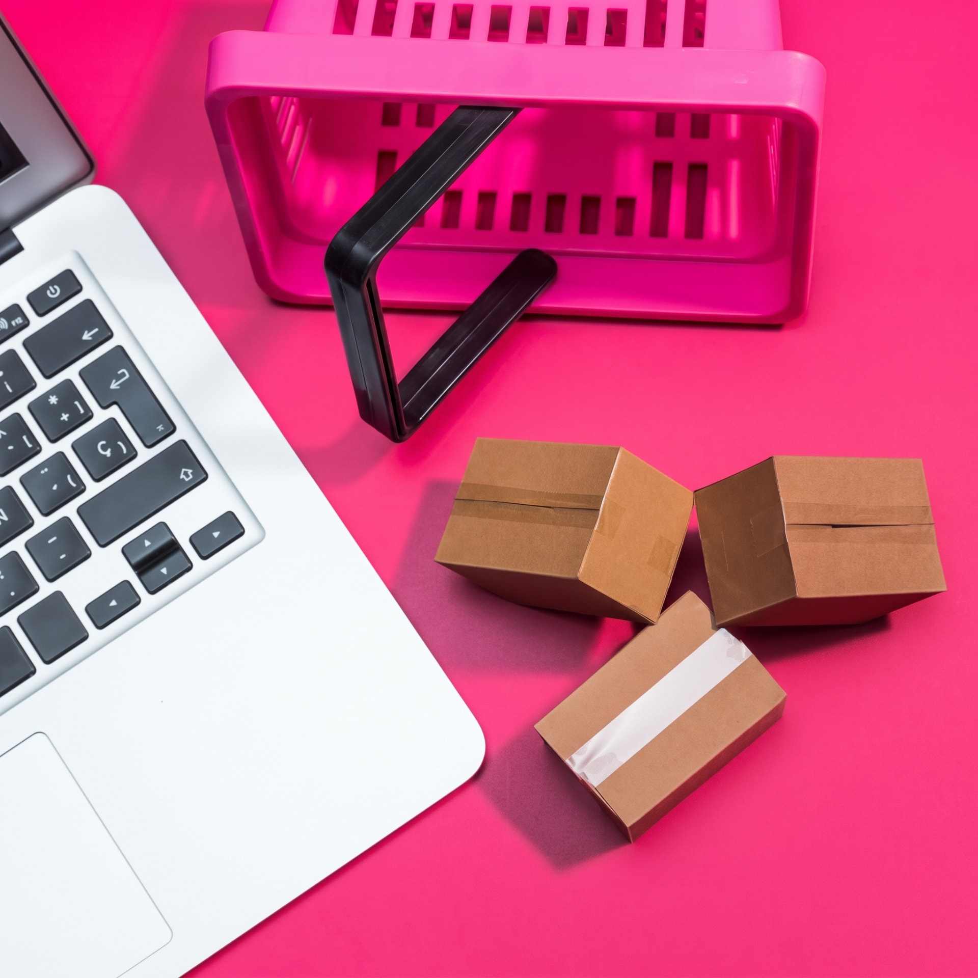 Caixas de pedidos e notebook sobre fundo rosa