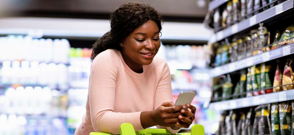 mulher mexendo no celular no mercado ilustra o que e customer experience e comportamento do consumidor no Cross border